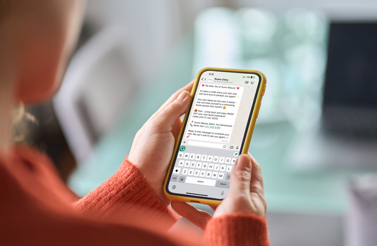 Person using a smartphone to engage with customers via messaging.