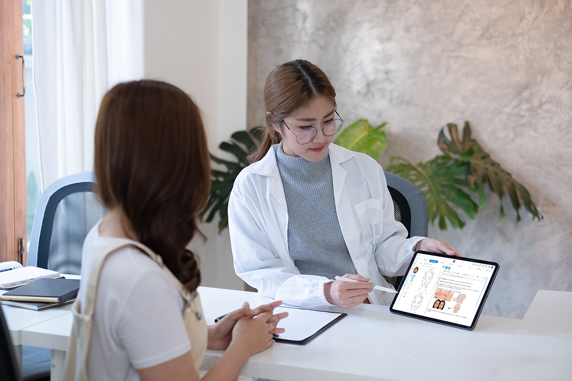 An aesthetic doctor shows patient the case notes along with a before-and-after treatment collage on Aoikumo™.